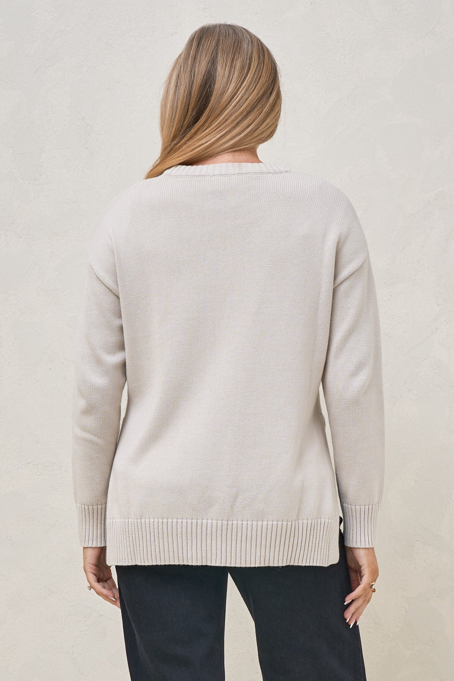 Back view of pregnant model wearing knit maternity jumper with ribbed hem detail