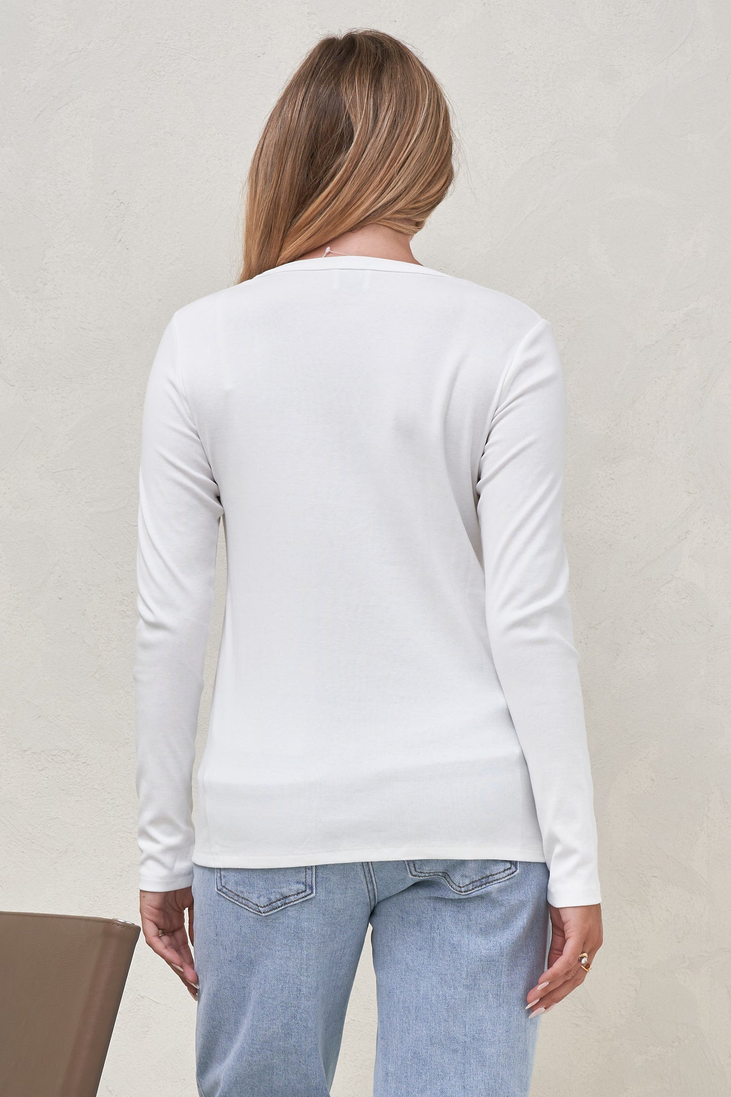 Back view of white long sleeve maternity top with light blue maternity jeans