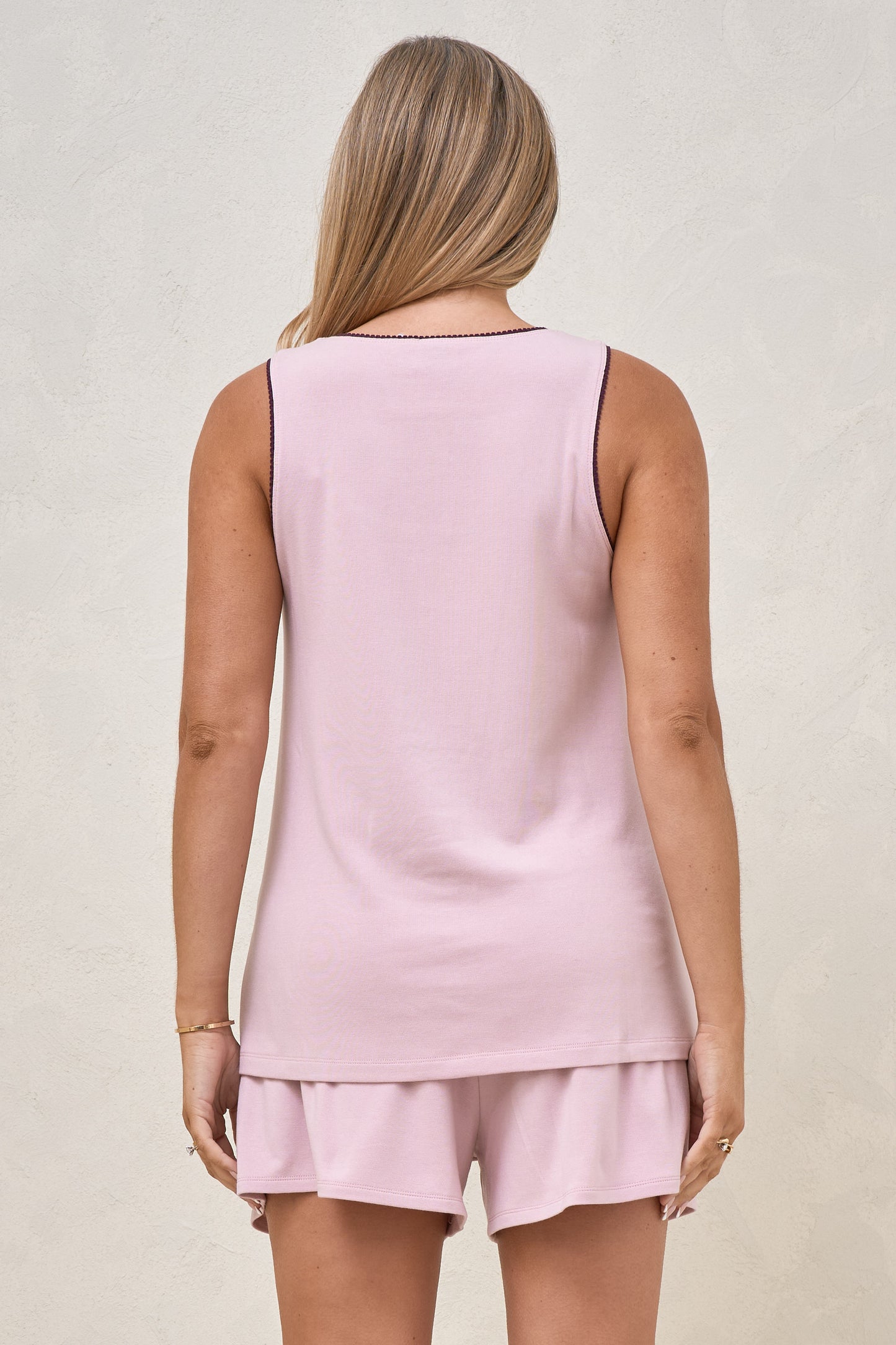 Back view of pregnant model wearing a sleepwear tank top with cute trim detail