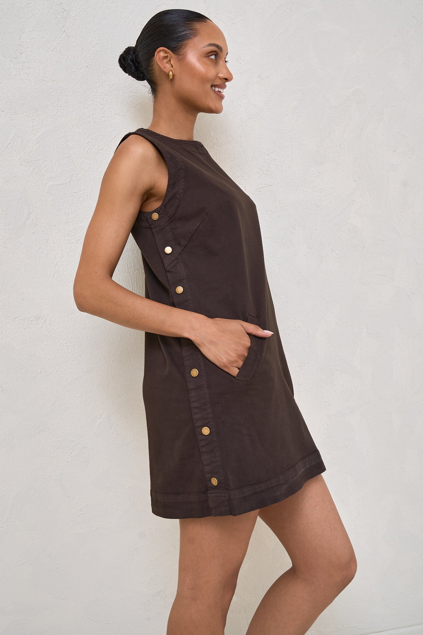 A woman wearing maternity snap side dress in chocolate with gold buttons down the side of the dress 