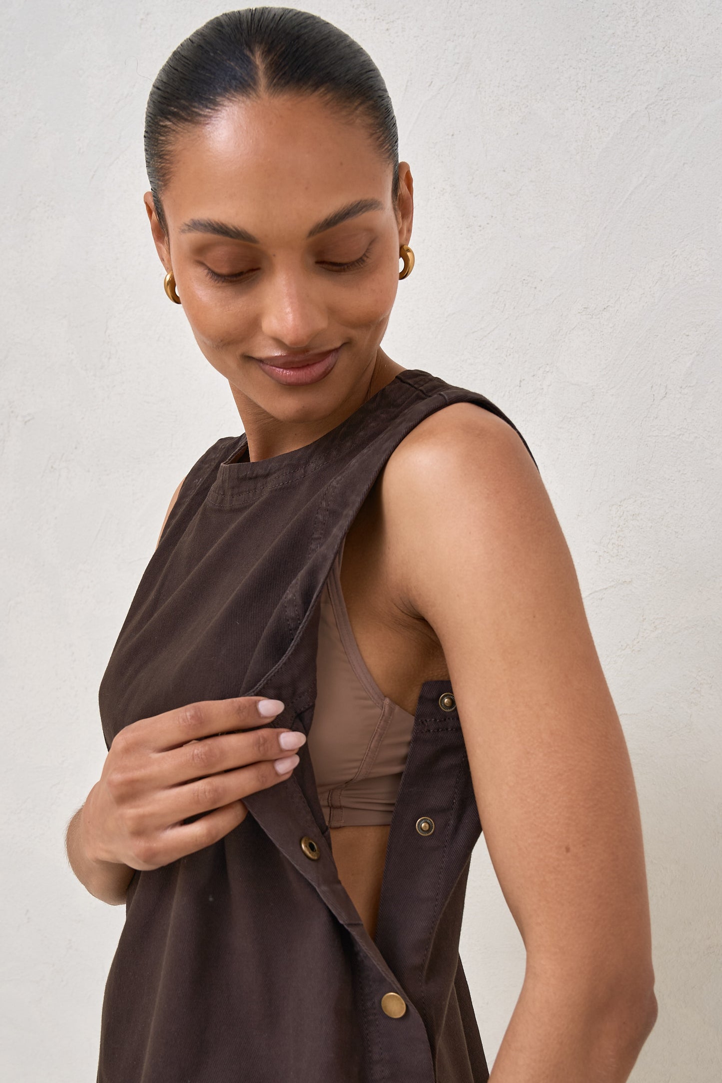 Close up of a woman wearing maternity snap side dress in chocolate with gold buttons down the side of the dress 