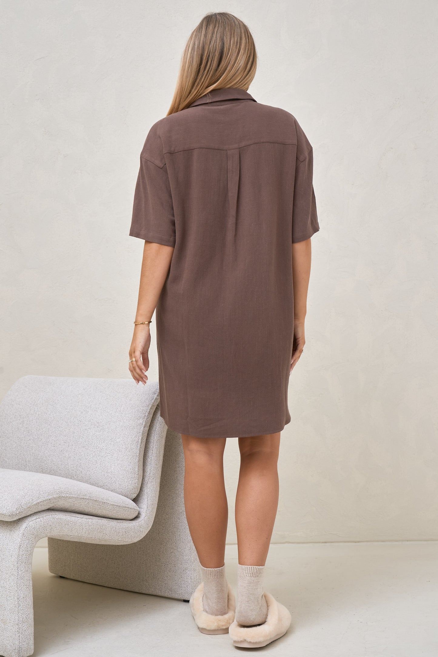 Back view of pregnant model wearing brown birth dress with collar