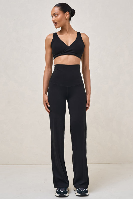A woman wearing maternity wide leg legging in black matched with a black nursing bra 