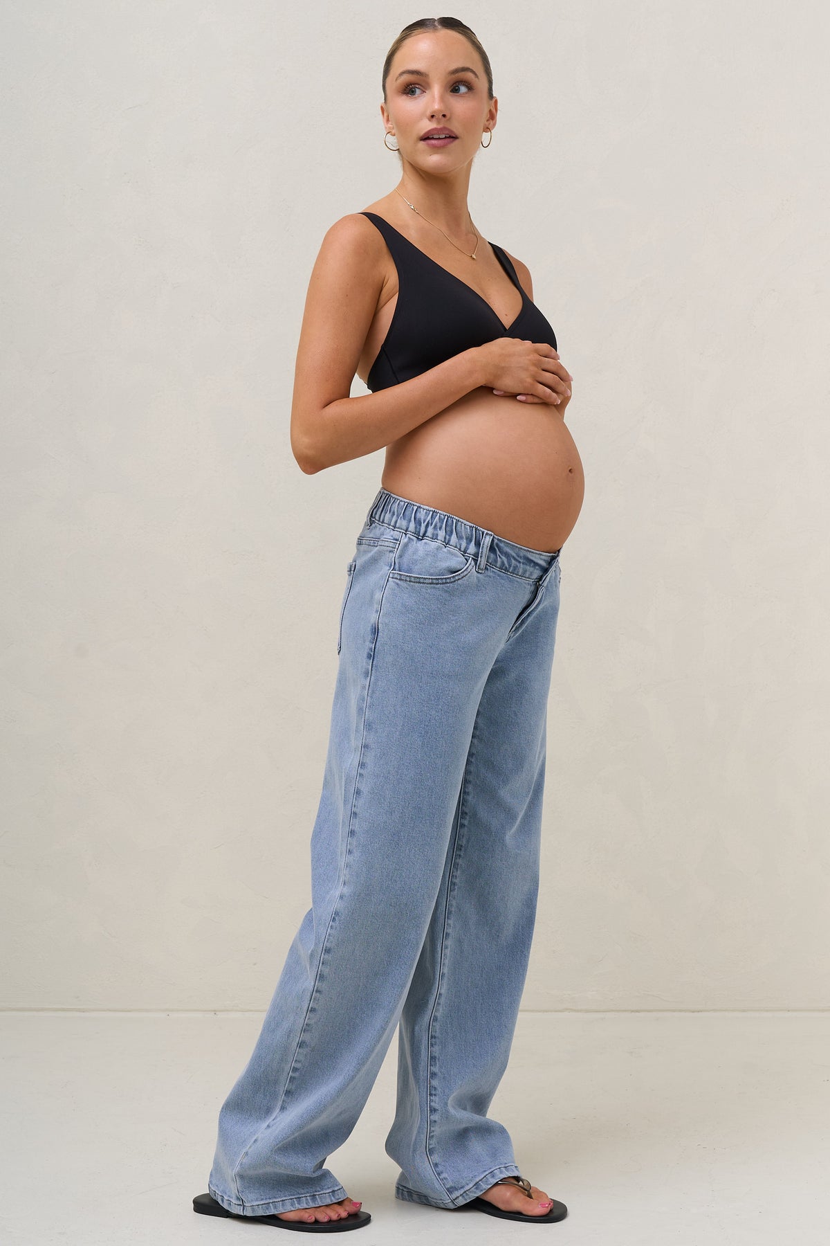 Baggy wide leg maternity jeans in blue – side view with under-bump waistband