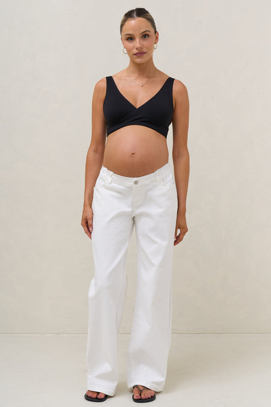 Baggy wide leg maternity jeans in white – front view on bump
