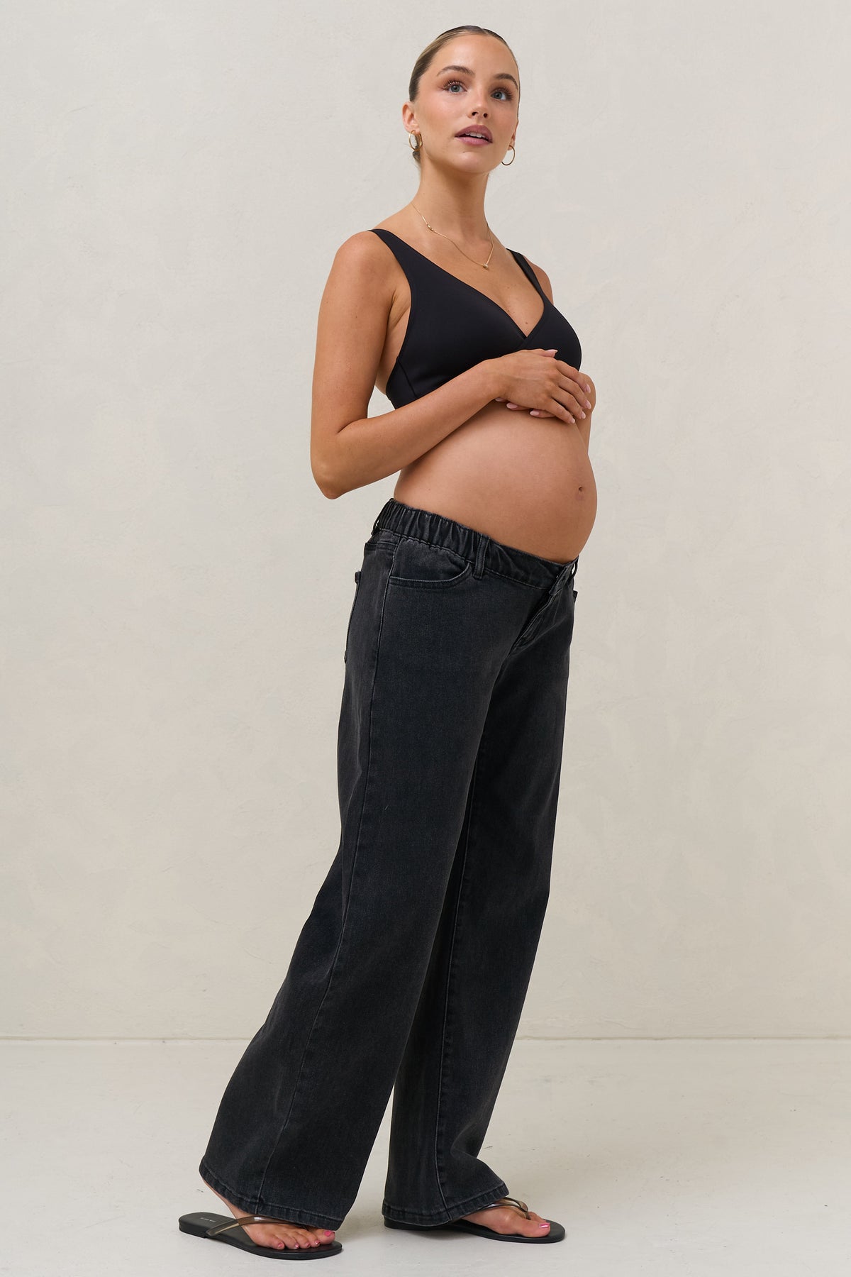 Baggy wide leg maternity jeans in black – side view with under-bump waistband