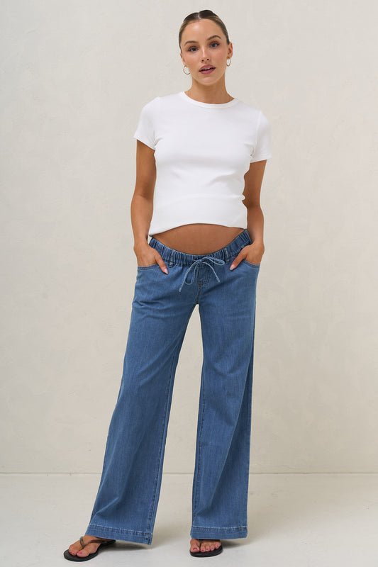 Wide leg maternity jeans in blue – front view under bump with white tee